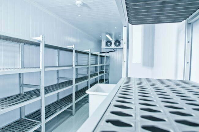 A cold storage room with metal shelving and refrigeration units